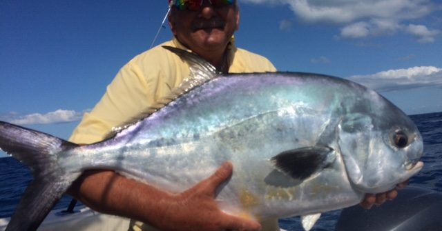 Russell Dell holding his trophy size permit caught off Marathon with Capt. Doug on a full day fishing charter.